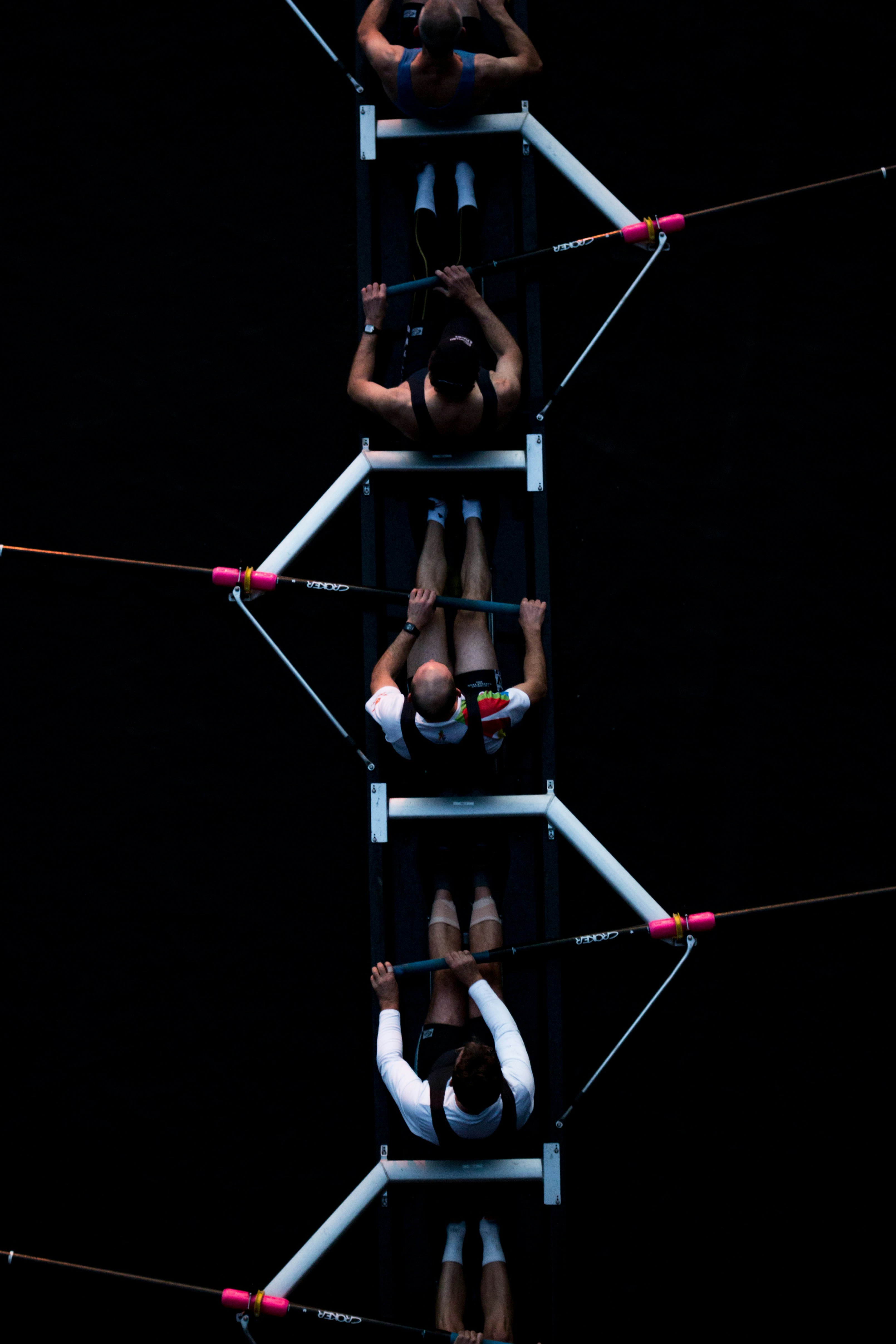 An aerial view of a rowing team paddling in unison.